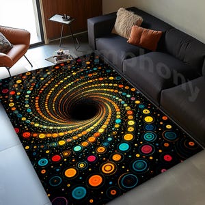May include: A black area rug with a spiral design. The rug features a central black vortex surrounded by concentric circles in shades of orange, yellow, blue, and red. The rug is rectangular and placed on a gray floor.