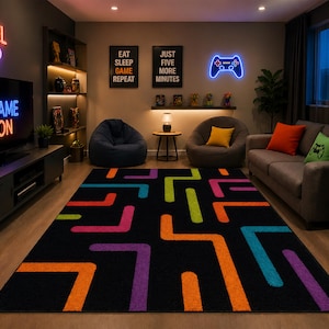 May include: A gaming room with a black rug featuring colourful geometric shapes. The room includes a TV with "GAME ON" neon sign, a "LEVEL UP" neon sign, and a controller neon sign. There are bean bag chairs, a sofa, and shelves with games.