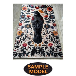 May include: Rectangular rug with a central image of a black crow with red detailing, surrounded by a floral design. The flowers are in orange, red, and blue hues, set against a white backdrop. The rug has a decorative border with a 'SAMPLE MODEL' text.