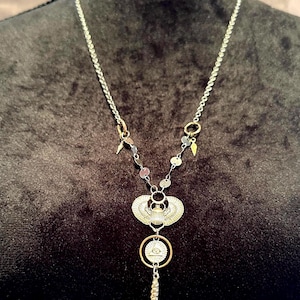 Collar de plata rediseñado y reutilizado con colgante de águila y pirámide.