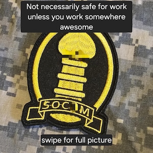 May include: A black and gold patch with the text "SOCIM" on a banner. The patch features a yellow design and is surrounded by a yellow border. The text "Not necessarily safe for work unless you work somewhere awesome" is at the top, and "swipe for full picture" is at the bottom.