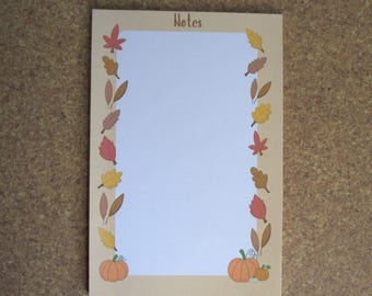 May include: A tan notepad with a white interior and a border of fall leaves. The top of the notepad says "Notes". There are two pumpkins at the bottom of the notepad.