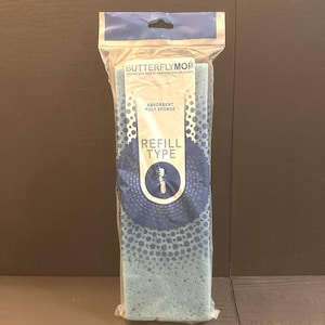 Puede incluir: Una recarga de esponja de poliéster absorbente azul para ButterflyMop, empaquetada en plástico transparente. El embalaje incluye el nombre de la marca e información del producto. La esponja tiene una superficie texturizada con pequeños agujeros.