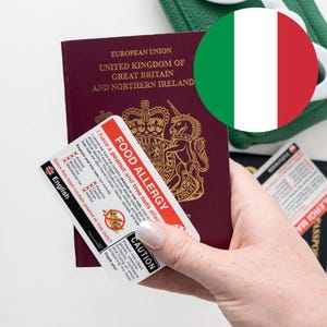 May include: A burgundy UK passport is held with a food allergy card. The card has red and white text that reads "FOOD ALLERGY" and lists potential allergens. An Italian flag is in the background.