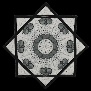 May include: A white and black star-shaped textile with a symmetrical design. The design features gray floral-like shapes and a central circular pattern. The edges are outlined in black, and the background is speckled with small black dots. The text "VegasGood.com" is visible.