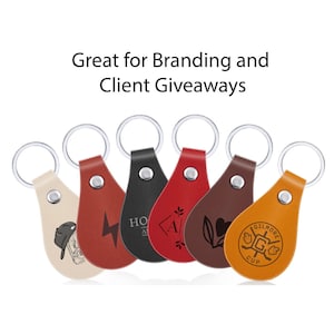 May include: A collection of leather keychains in various colors, including tan, red, black, and brown. Each keychain features a unique design or logo and a silver keyring. The text "Great for Branding and Client Giveaways" is displayed above.