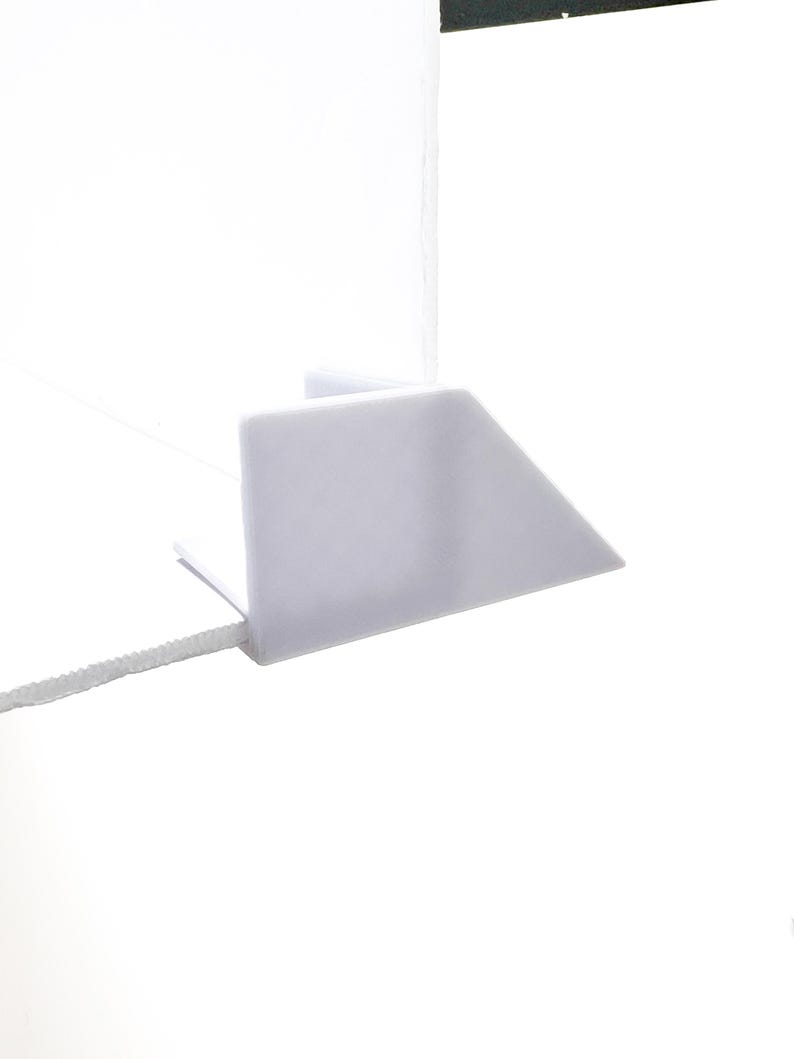 May include: White plastic corner shelf bracket with a right angle design.