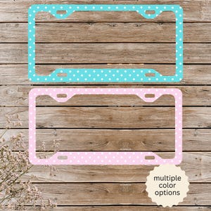 May include: Two rectangular license plate frames featuring a white polka dot pattern. The top frame is turquoise blue, and the bottom frame is light pink. Each frame includes four mounting holes for attachment to a vehicle license plate.