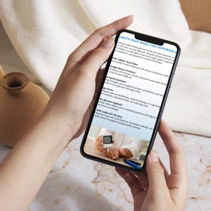 May include: A smartphone displays a screen with the text "HABITS THAT MAKE THE DIFFERENCE" and tips for managing blood glucose levels. The image includes a close-up of a person using a glucose meter. The phone is held in a person's hands.