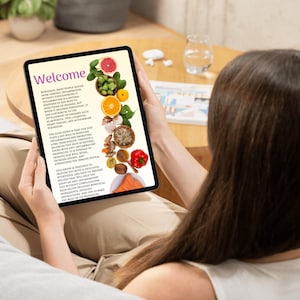 May include: A tablet screen displaying a welcome message and a list of healthy foods, including fruits, vegetables, and fish. The text on the screen reads "Welcome" and "The good news is that our diet plays a key role in reducing inflammation and promoting long-term health through a balanced diet rich in natural foods with anti-inflammatory properties. It is possible to improve our wellbeing, increase energy, and strengthen the immune system."
