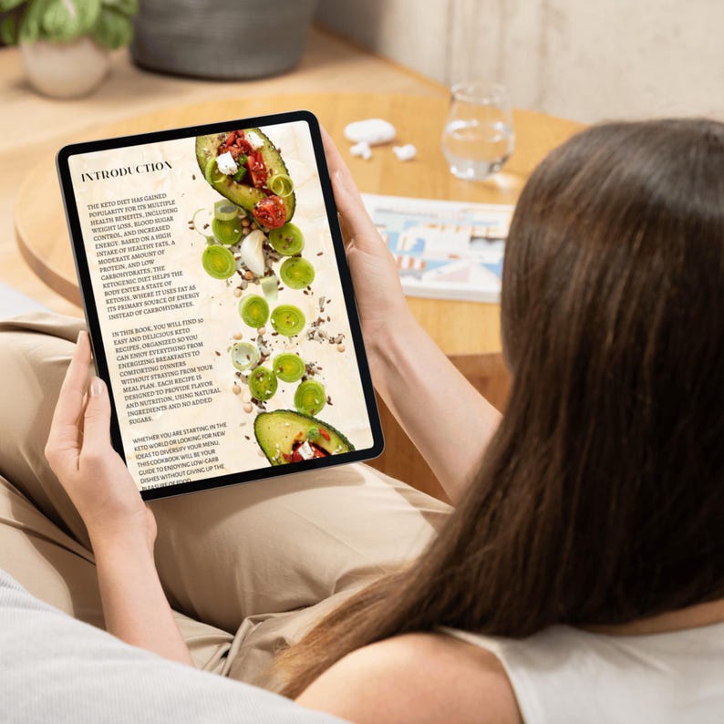 Pu&ograve; includere: Una persona sta leggendo un tablet digitale con un libro di cucina keto sullo schermo. Lo schermo mostra un primo piano di un'insalata con avocado, uva verde e peperoni rossi. Il testo sullo schermo recita "Introduzione" e "La dieta chetogenica ha guadagnato popolarit&agrave; per i suoi molteplici benefici per la salute, tra cui la perdita di peso, il controllo dello zucchero nel sangue e l'aumento dell'energia.  Informazioni sulla dieta chetogenica:  &Egrave; una dieta ricca di proteine e povera di carboidrati. Aiuta il corpo a entrare in uno stato di chetosi, dove utilizza i grassi come fonte primaria di energia al posto dei carboidrati."