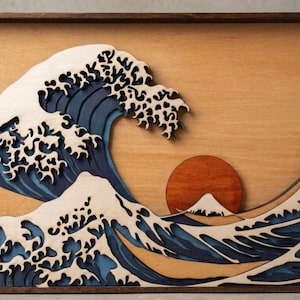 May include: Wooden wall art depicting a stylized ocean wave with a setting sun and a mountain in the background. The wave is layered in shades of blue and white, with a natural wood background and a dark brown frame.