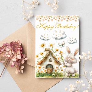 May include: A white bunny holding a bouquet of white flowers in front of a small cottage with a brown roof. The cottage is surrounded by white flowers and green grass. The background is white with three white clouds with smiley faces and the text "Happy Birthday!" in gold lettering.