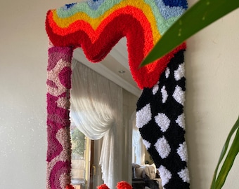 Alfombra rosa con estampado de cuadros y llamas arcoíris, espejo de pared