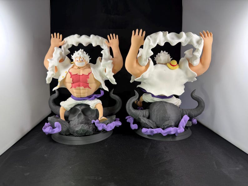 May include: Two white and red anime figurines of a character with white hair and a white beard. The figurines are posed with their arms raised and are wearing white clothing. The figurines are sitting on black bull skulls with purple smoke.