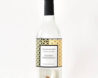 May include: A clear glass bottle with a black cap, filled with cocktail infusion ingredients. The label reads "Blossom & Barrel" and "Coconut Passionfruit." The bottle contains spices and dried fruit, suggesting a tropical flavor profile.