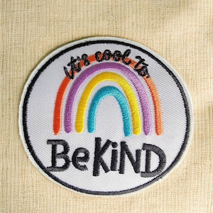 May include: A white circular patch with a rainbow and the text "It's cool to be kind".