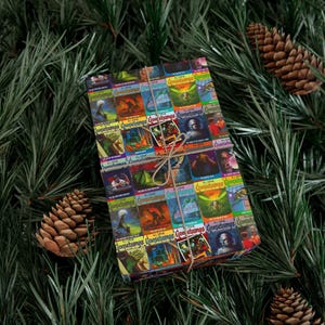 May include: A gift wrapped in colorful wrapping paper featuring a pattern of Goosebumps book covers. The paper is a collage of different book covers with various titles and illustrations. The gift is tied with a brown twine bow.