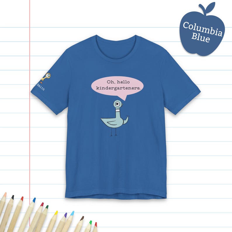 May include: A blue short-sleeve t-shirt featuring a cartoon pigeon graphic with a pink speech bubble containing the text Oh, hello kindergarteners. The sleeve displays a small icon of a magnifying glass and the text Smith in white lettering.