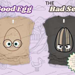 May include: Two t-shirts with cartoon egg and seed designs. The tan shirt features an egg with glasses and the text "The Good Egg." The dark gray shirt displays a seed with an angry face and the text "The Bad Seed."