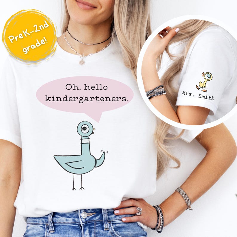 May include: A white t-shirt featuring a light blue cartoon pigeon with a pink speech bubble containing the text Oh, hello kindergarteners. The sleeve displays a small yellow bird graphic above the custom text Mrs. Smith in black lettering.