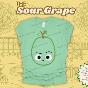 May include: A light green t-shirt with a cartoon illustration of a sour grape. The grape has a stem and leaf, with a grumpy face. The text "THE Sour Grape" is above the graphic.
