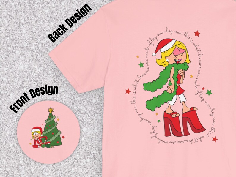 May include: Pink t-shirt with a cartoon illustration of a girl wearing a green scarf and red boots. The text "This is what dreams are made of hey now hey now this is what dreams are made of hey now hey now" is printed around the illustration.