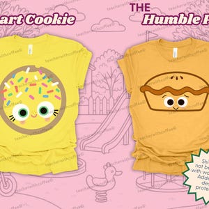 May include: Two yellow t-shirts with cartoon food designs. One shirt features a cookie with sprinkles and the text "The Smart Cookie." The other shirt displays a pie with a face and the text "The Humble Pie."