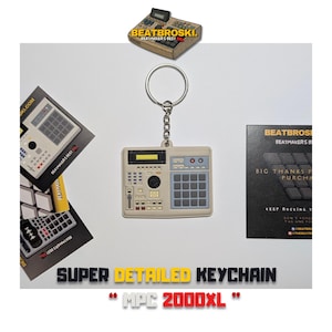 May include: A beige and grey keychain shaped like a classic MPC 2000XL sampler. The keychain is attached to a silver key ring.