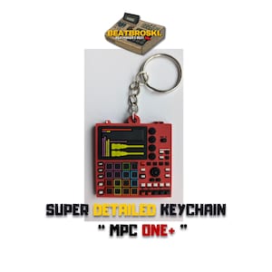 Puede incluir: Llavero rojo y negro con forma de sampler musical MPC One+. El llavero tiene un anillo de llave plateado. El texto "SUPER DETAILED KEYCHAIN" y "MPC ONE+" está impreso debajo del llavero.