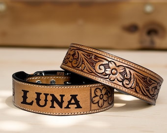 Puede incluir: Dos collares de perro de cuero marrón. Un collar presenta el nombre "LUNA" en letras negras. El otro collar tiene un diseño floral en relieve. Ambos collares tienen un interior negro y herrajes metálicos.
