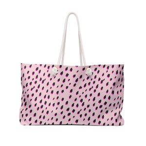 Op de afbeelding: Een grote draagtas met een lichtroze achtergrond en een patroon van zwarte en magenta penseelstreken. De tas heeft witte touwhandvatten en witte decoratieve knopen in de bovenhoeken.