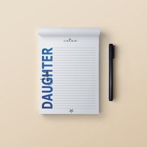 May include: A white notepad with blue gradient text that says "Notes from Daughter" and the word "notes" at the top. A black pen is to the right of the notepad.