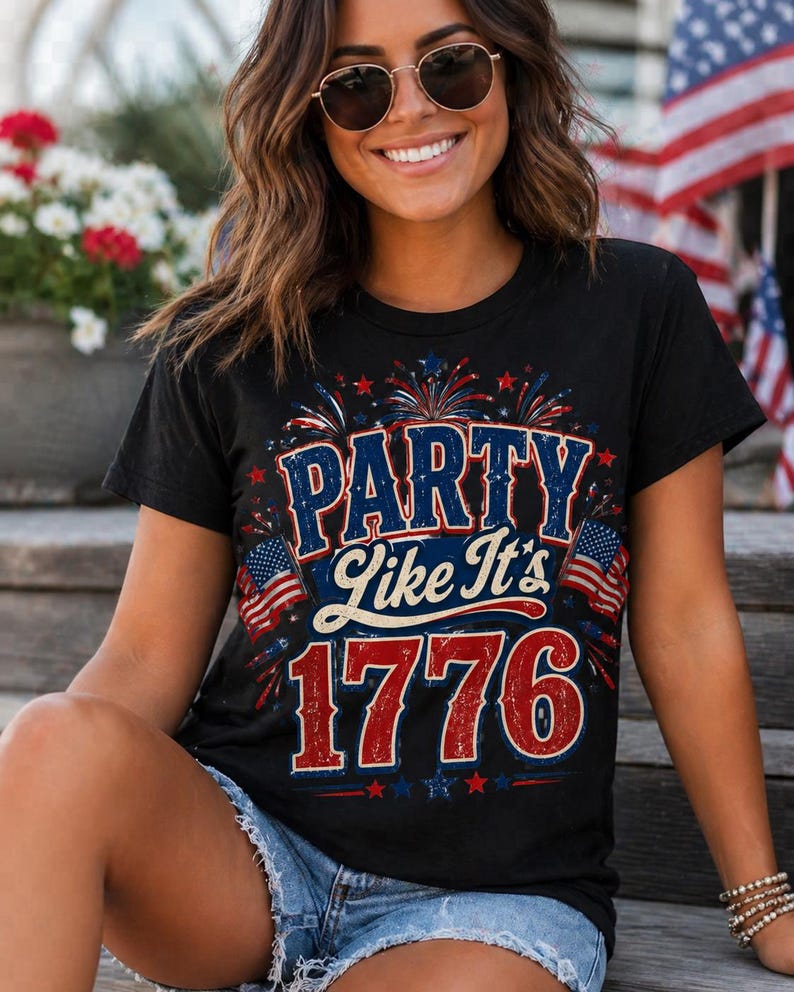May include: Black t-shirt with the text "PARTY Like It's 1776" in red, white, and blue. The design includes fireworks and American flags, celebrating the spirit of the Fourth of July.