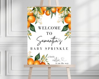 May include: Welcome to Samantha's Baby Sprinkle sign with a white background and orange blossoms. The text reads "Welcome to Samantha's Baby Sprinkle, a little cutie is on the way".