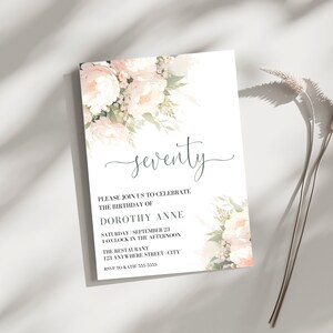 Op de afbeelding: Een witte uitnodiging met een bloemenontwerp in roze en groene tinten. De tekst luidt "zeventig" en bevat details voor een verjaardagsfeest voor Dorothy Anne.