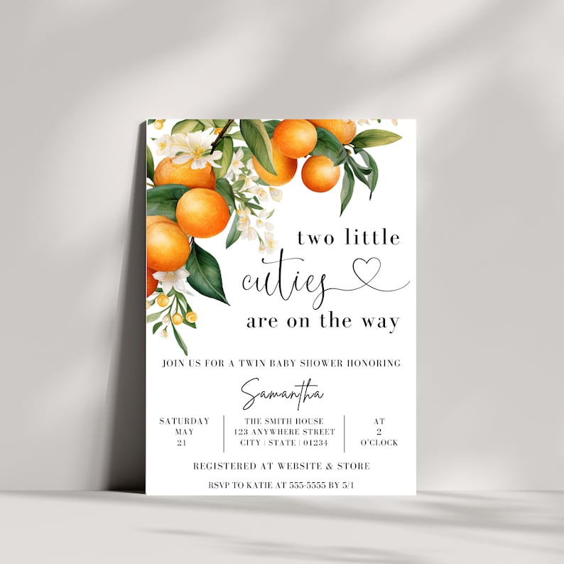 Pu&ograve; includere: Un invito a una festa di baby shower bianco con un design floreale con fiori d'arancio e frutta. Il testo recita "two little cuties are on the way" e include i dettagli dell'evento, tra cui la data, l'ora e il luogo.