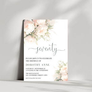 Op de afbeelding: Een witte uitnodiging met een bloemenontwerp in roze en groene tinten. De tekst luidt "zeventig" en bevat details voor een verjaardagsfeest voor Dorothy Anne.