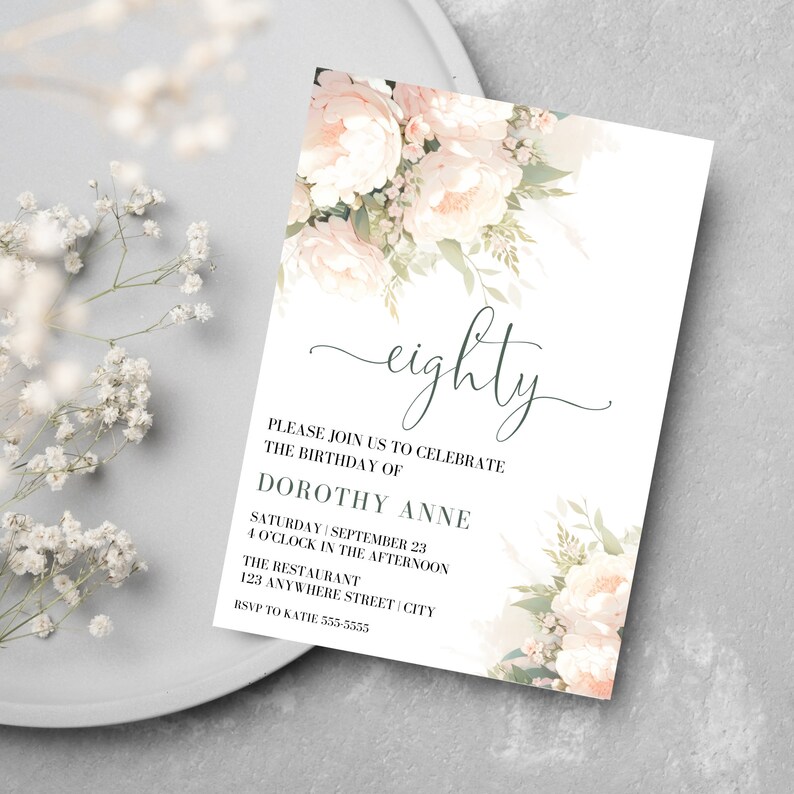 May include: A white invitation card with a floral design in shades of pink and green. The text on the card reads "eighty" and includes details for a birthday celebration for Dorothy Anne.
