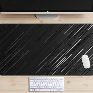 Pode incluir: Tapete de mesa preto com um padrão de linhas brancas diagonais. Um teclado branco e um rato branco estão no tapete de mesa.
