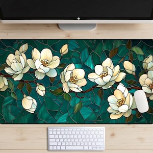May include: A stained glass style mousepad featuring a white magnolia flower design on a teal green background.