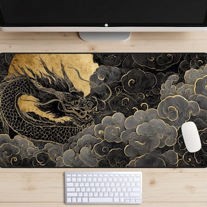 Puede incluir: Alfombrilla de ratón negra y dorada con un diseño de dragón. La imagen muestra una ilustración detallada de un dragón, un sol dorado y nubes arremolinadas. El diseño tiene patrones intrincados y un contraste llamativo. Se ven un ratón y un teclado blancos.
