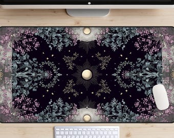 May include: A rectangular desk mat with a celestial design on a dark background. The mat features a central sunburst design with a full moon, surrounded by floral and botanical elements in grey, pink, and gold. A keyboard and mouse are visible.