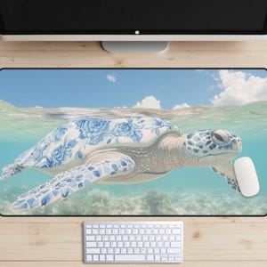 May include: A blue and white porcelain sea turtle swims in clear turquoise water. The turtle's shell is decorated with a floral pattern. The background is a bright blue sky with white clouds.