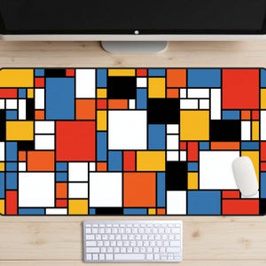 Könnte beinhalten: Eine rechteckige Schreibtischunterlage mit einem geometrischen Gittermuster aus verschieden großen Quadraten und Rechtecken in den Farben Rot, Blau, Gelb, Orange, Schwarz und Weiß, getrennt durch dicke schwarze Linien, mit einer weißen Computermaus.
