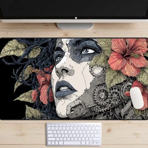 May include: A black rectangular mouse mat featuring a detailed illustration of a woman's face, with mechanical elements integrated into her features. The design incorporates red hibiscus flowers and green leaves, with a white mouse and keyboard visible.