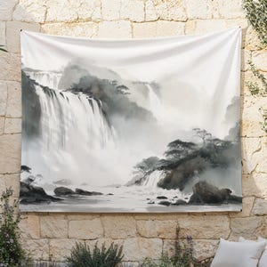 May include: A large white tapestry featuring a serene waterfall scene in shades of gray and white. The artwork depicts cascading water, rocky terrain, and misty atmosphere, creating a tranquil landscape. The tapestry is hung on a stone wall.
