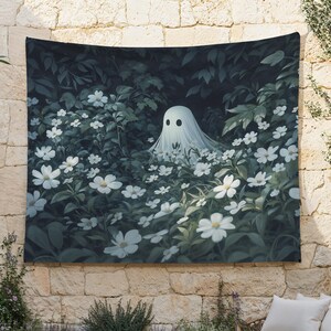 May include: A white ghost with a friendly face peeks out from a field of white flowers. The flowers are surrounded by dark green leaves and a dark background.