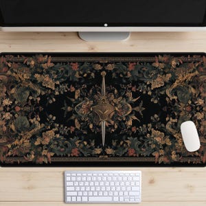 May include: A black and gold patterned mousepad with a floral design and a sword in the center. The mousepad is on a wooden desk with a keyboard and a computer monitor.