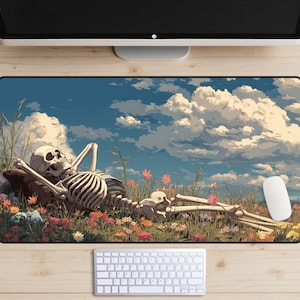 Puede incluir: Alfombrilla de ratón rectangular con un esqueleto relajado en un campo de flores coloridas bajo un cielo azul con nubes esponjosas. Un ratón de ordenador blanco es visible en el lado derecho.